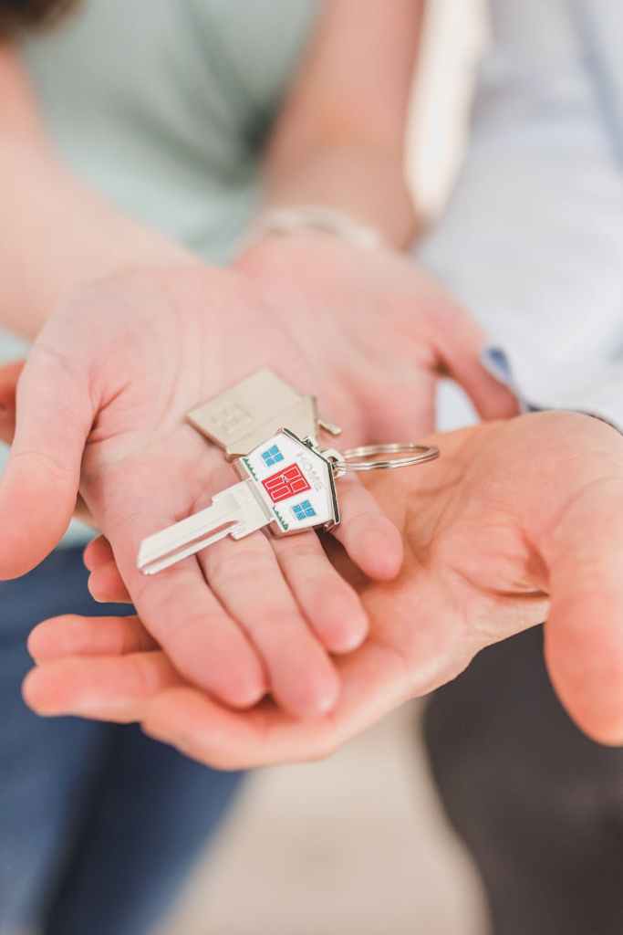 people holding a house shaped key